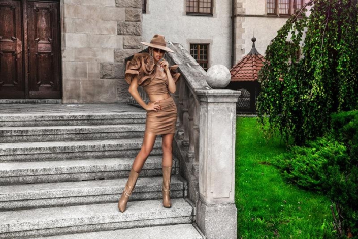 Moderne Frau in beigem Sommeroutfit mit Hut, ideal für eine individuelle Stilberatung in Hannover.